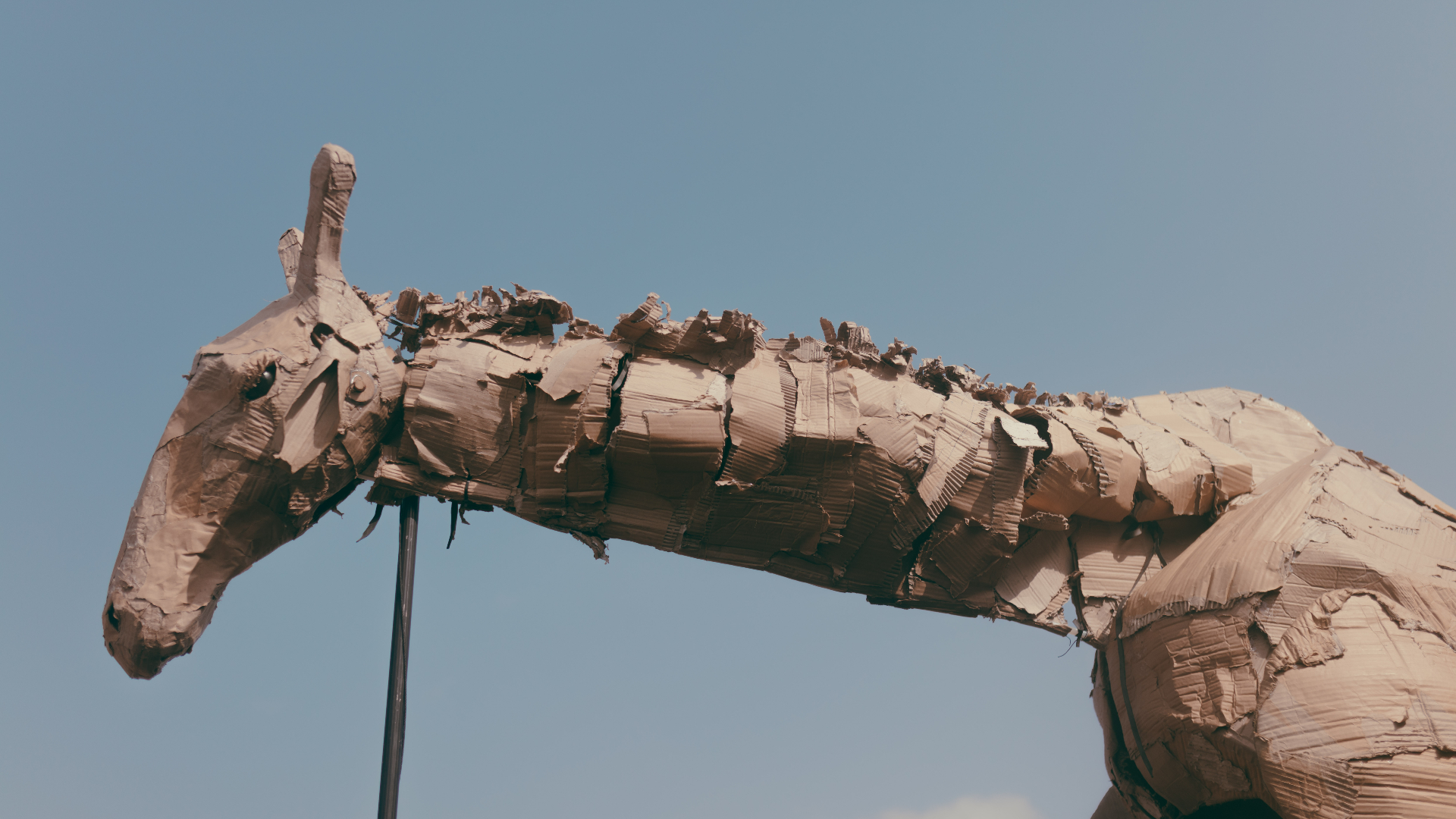 Cardboard giraffe puppet against the Lagos sky