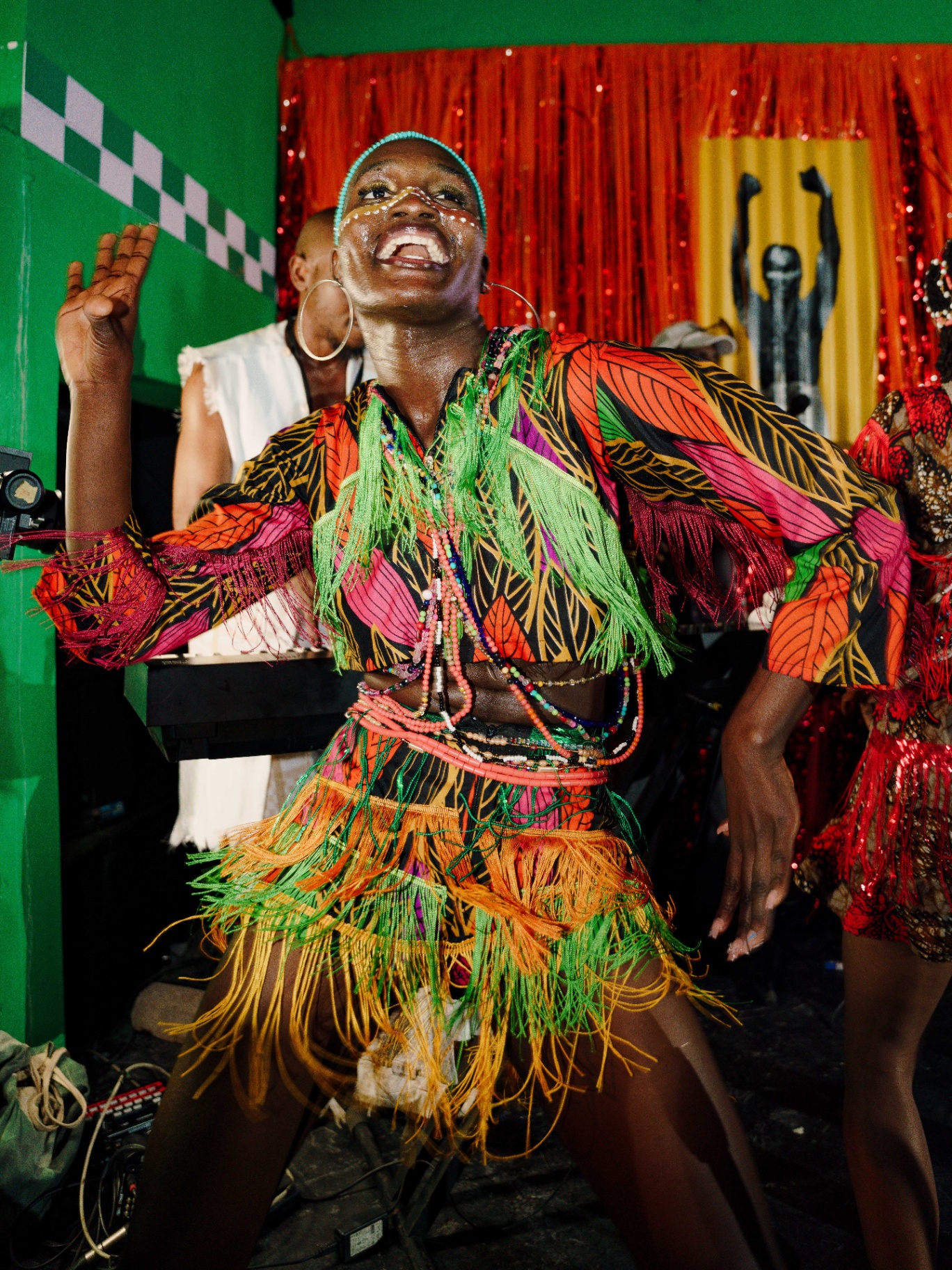 Dancer in beaded fringe costume performing at Afrobeat Rebellion