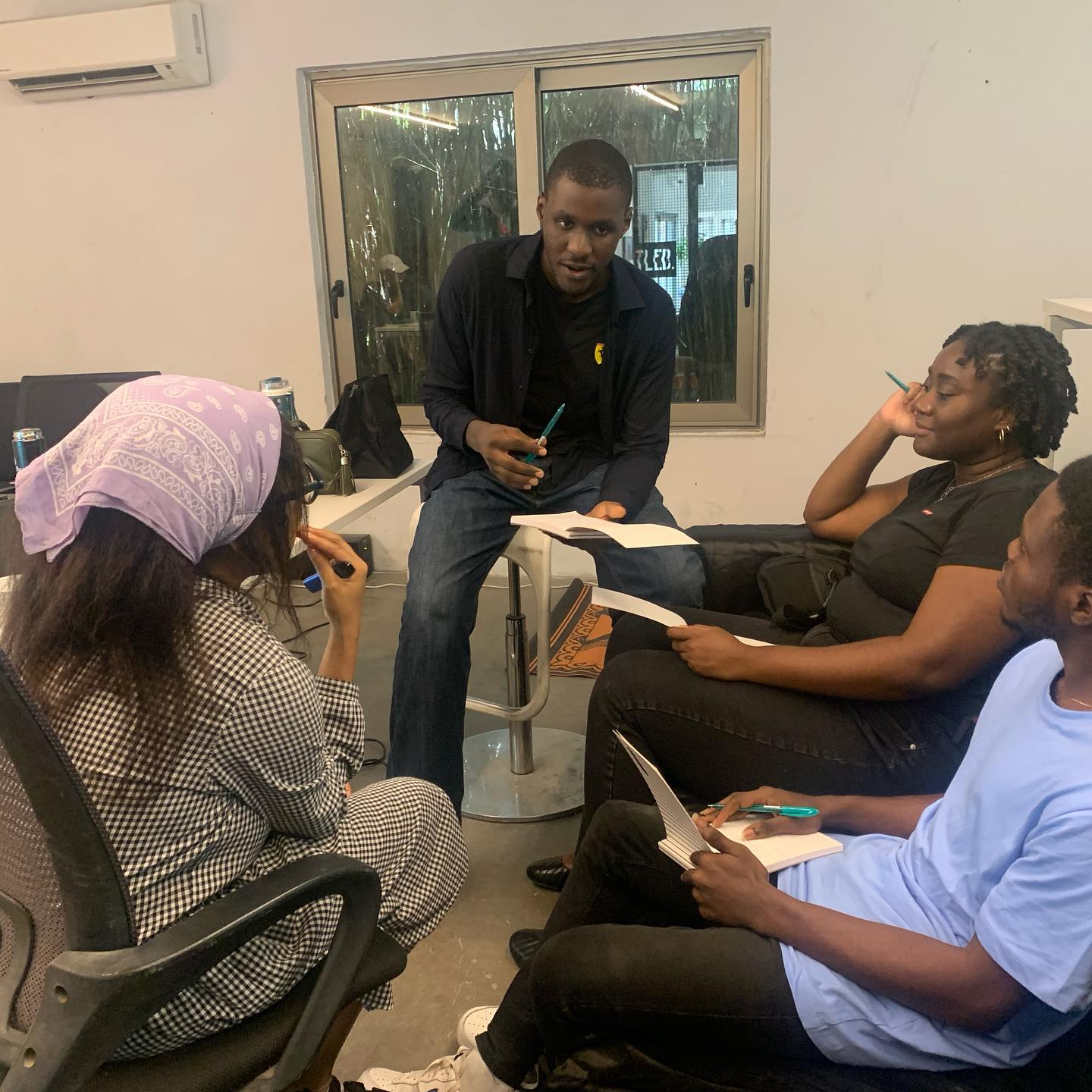 Participants seated in a circle exchanging pages during a Manifesto Seeds writing session