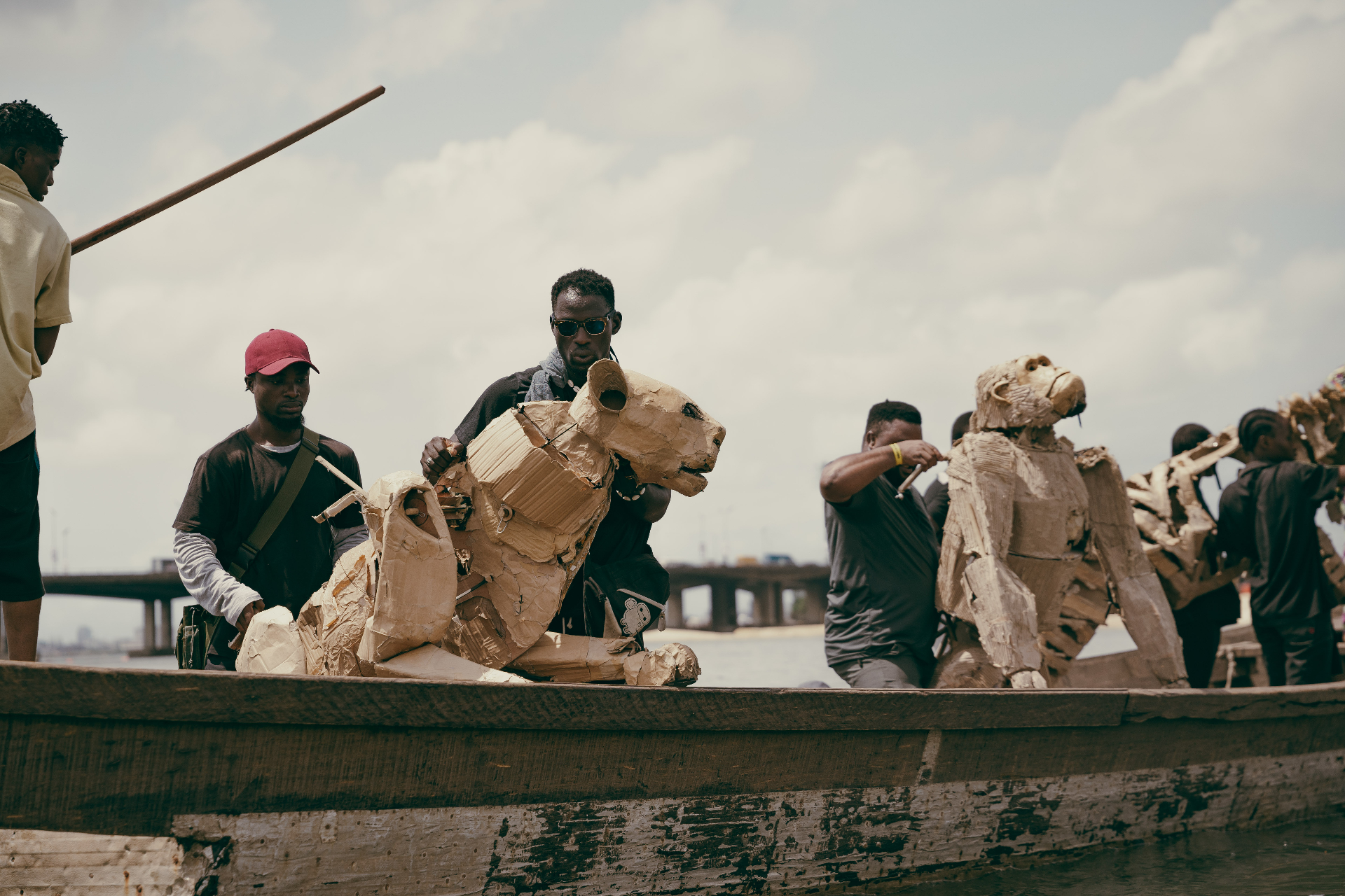Cardboard animal sculptures transported by boat across the water
