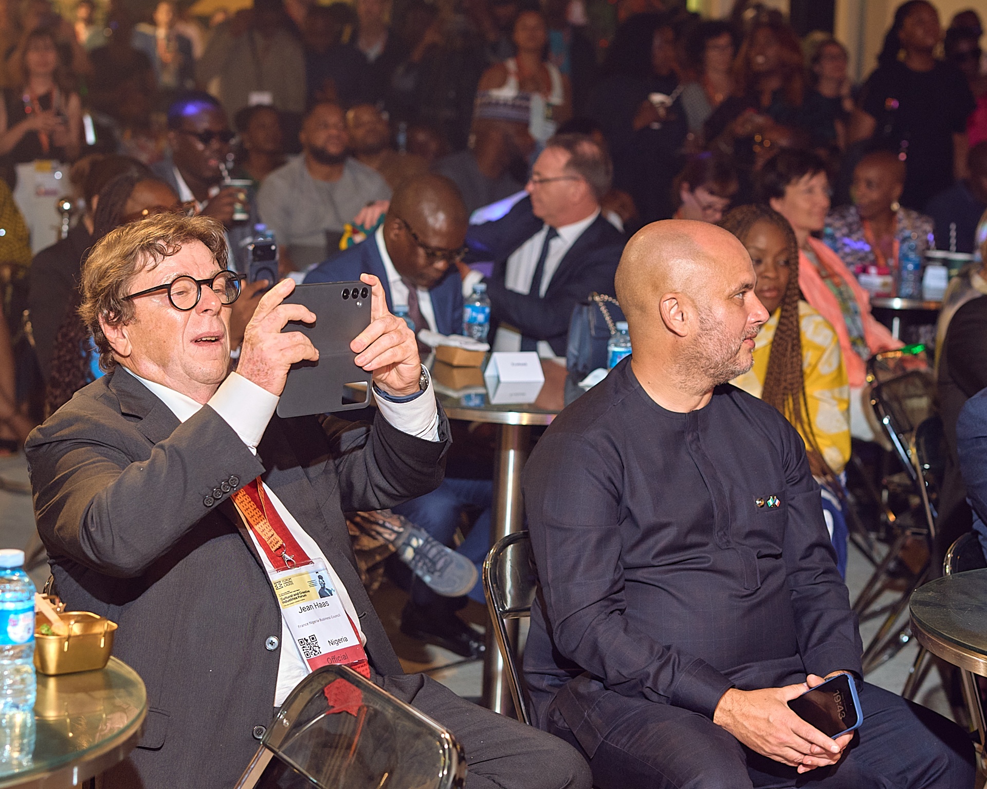 Audience members filming the Afrobeat Rebellion performance from their table