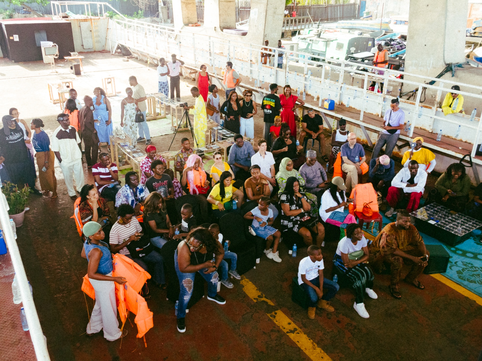 Aerial view of a large seated audience wearing life jackets during the Library on the Lagoon public programme at the Lagos ferry terminal