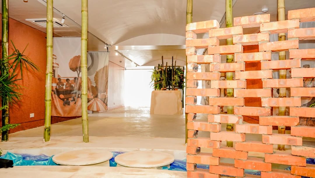 MatriAér Lab installation view with a woven brick screen and printed textile banners inside CCA Lagos