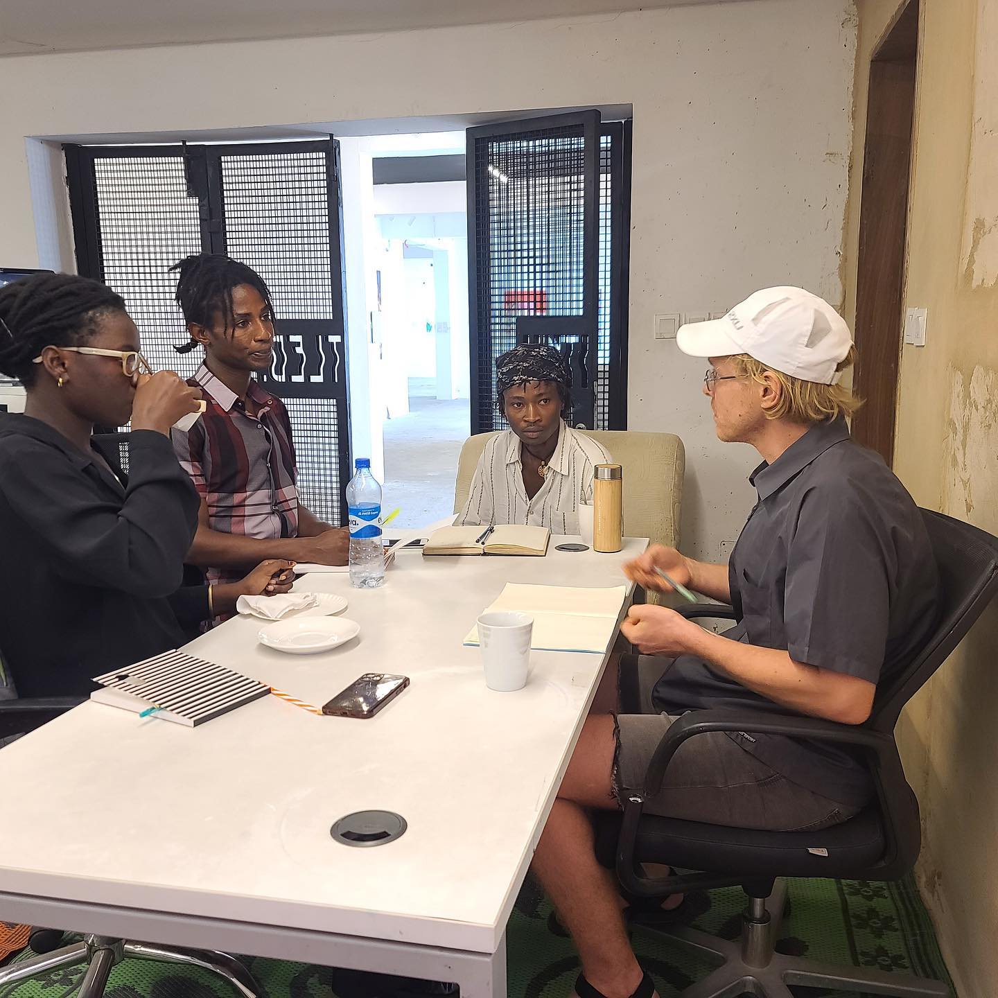 Small-group discussion around a workshop table with notebooks and pens